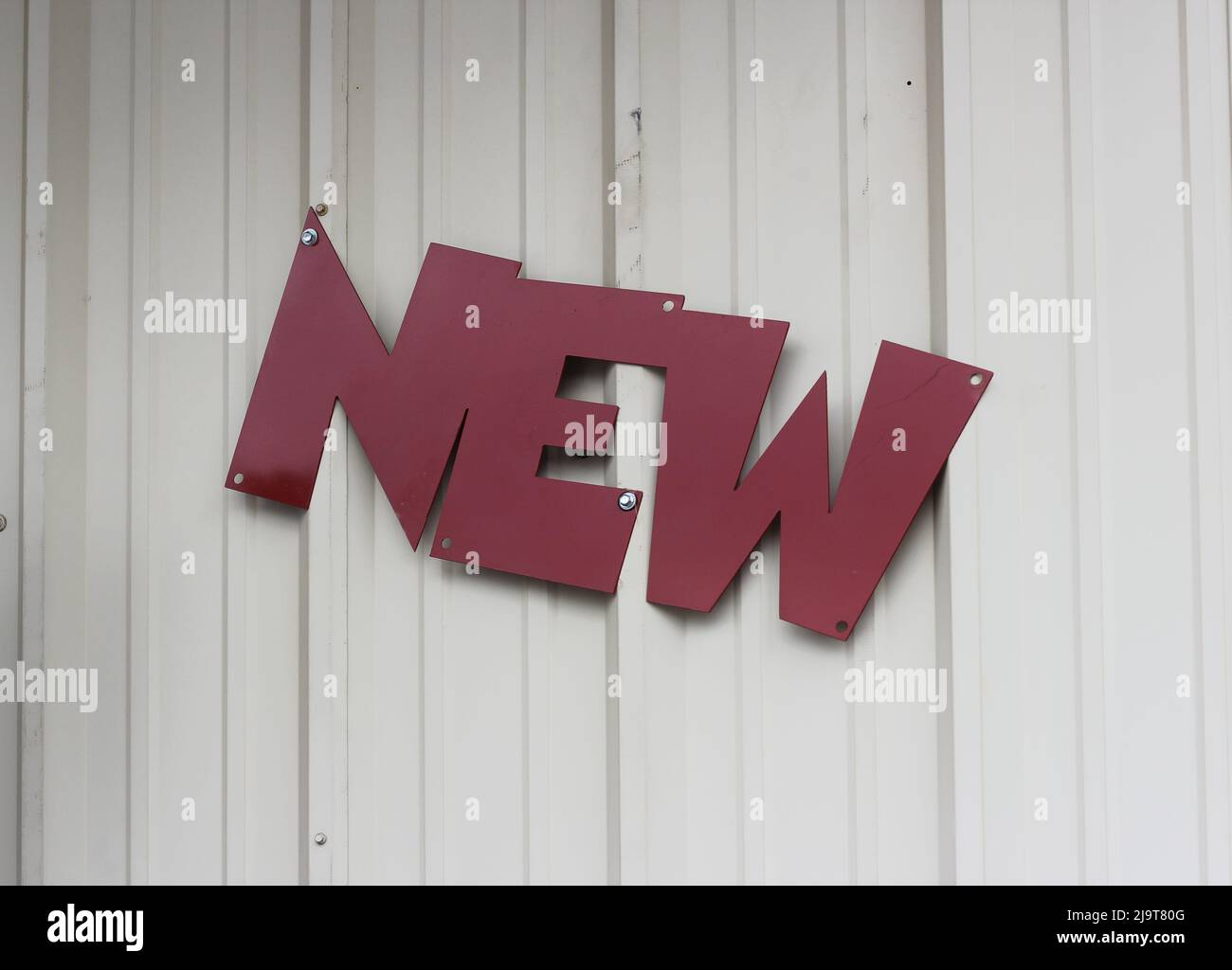 Panneau métallique vintage sur le mur extérieur des petites entreprises locales - Nouveau Banque D'Images