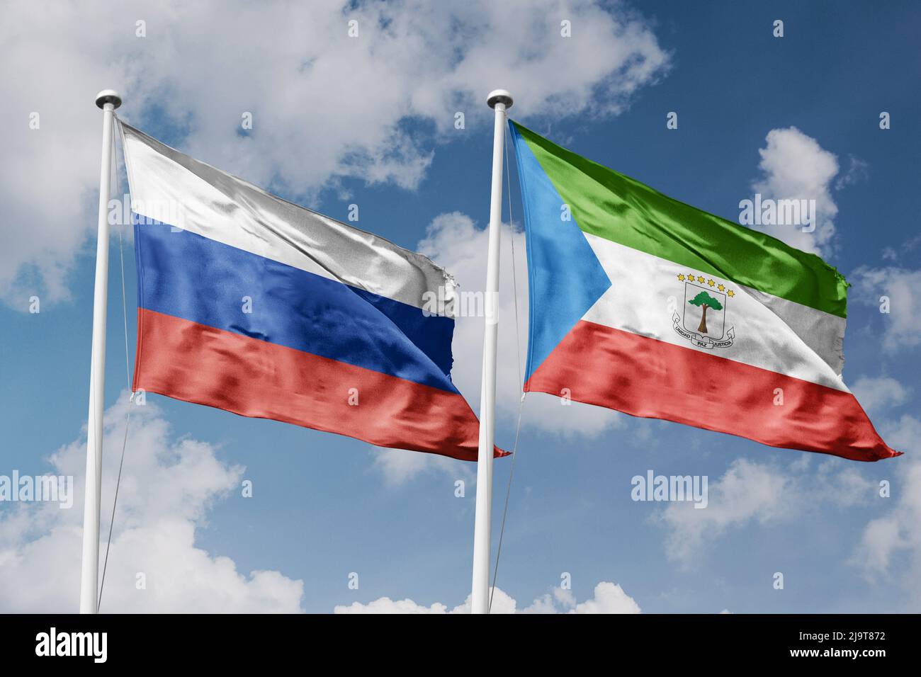 Russie et Guinée équatoriale deux drapeaux sur les mâts et fond bleu ciel nuageux Banque D'Images