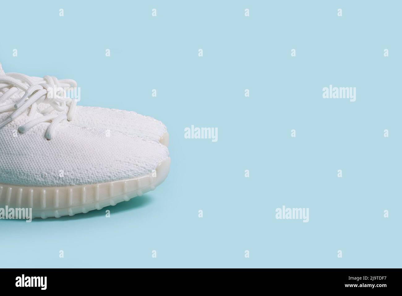 Une paire de sneakers blanches sur fond bleu Banque D'Images Une paire de sneakers blanches sur fond bleu Banque D'Images
