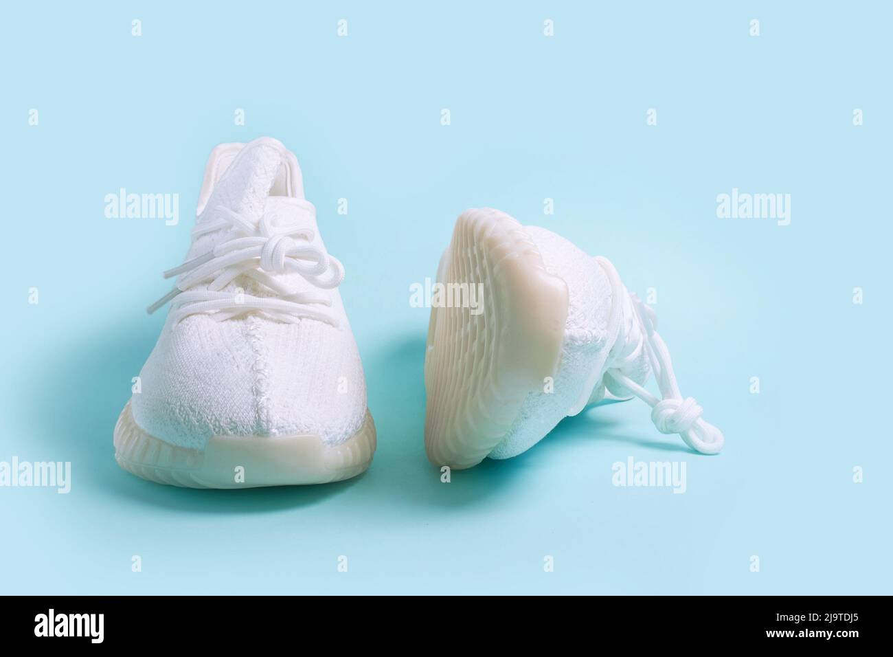 Une paire de sneakers blanches sur fond bleu Banque D'Images Une paire de sneakers blanches sur fond bleu Banque D'Images