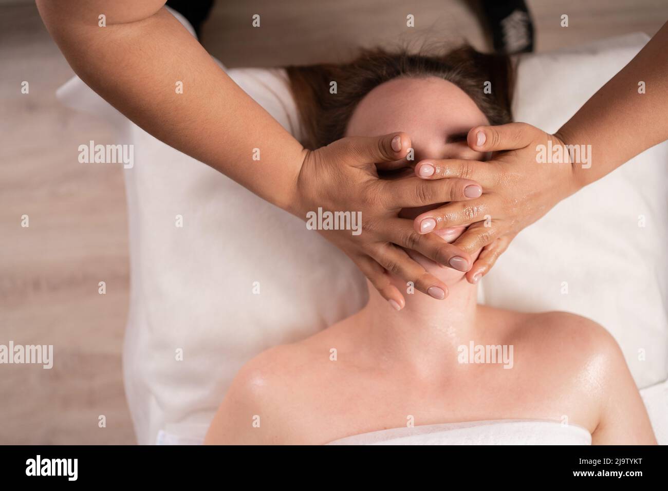 Jeune femme en gros plan bénéficiant d'un massage au spa, soin de beauté du visage. Femme bénéficiant d'un massage au spa au salon de beauté. Vue de dessus Banque D'Images