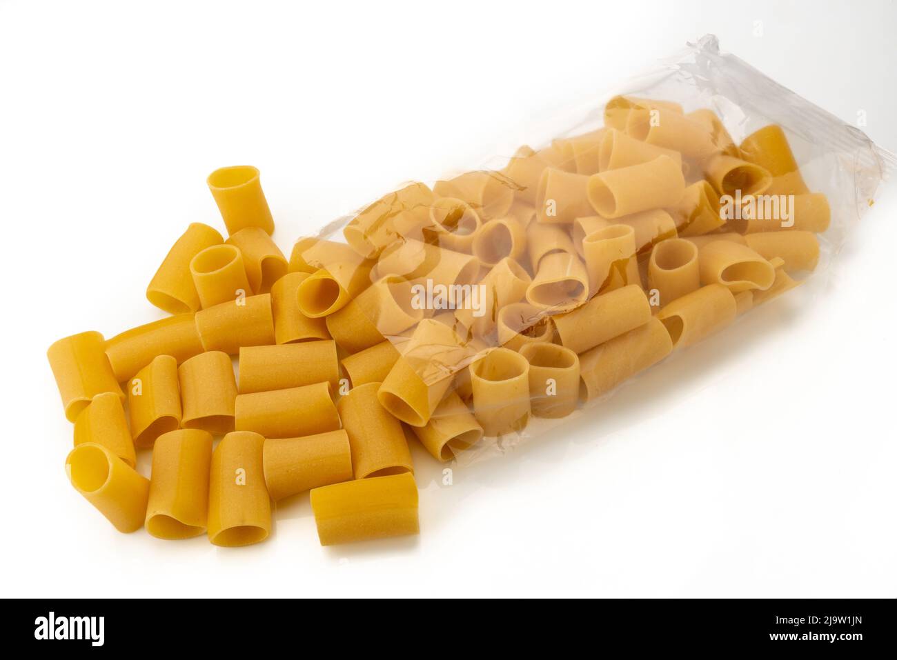 Pâtes Paccheri provenant d'un sac transparent isolé sur macaroni blanc typiquement italien de Gragnano Banque D'Images