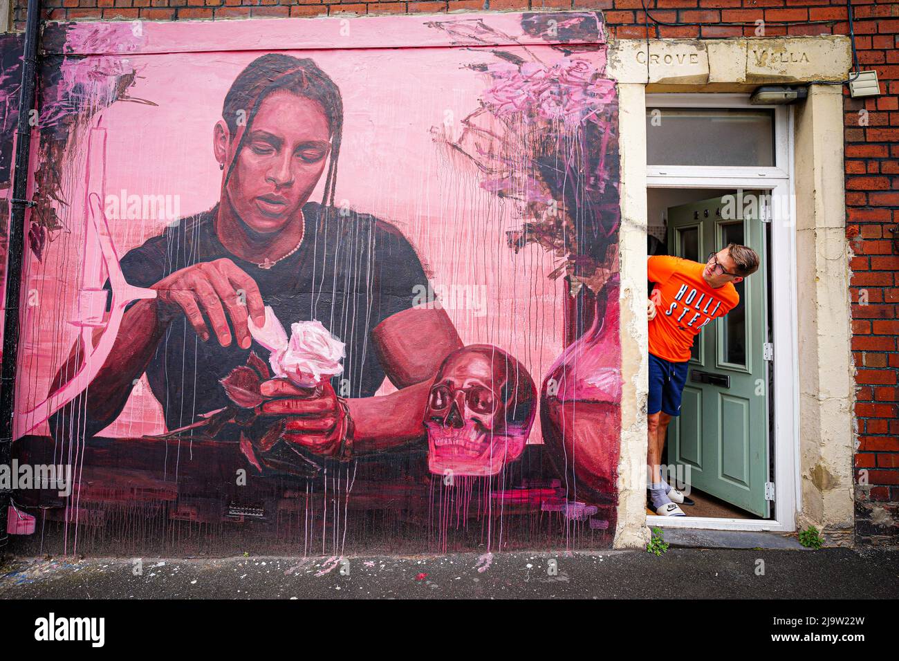 Un homme regarde une nouvelle œuvre d'art de rue à l'extérieur de sa maison à Bedminster, Bristol, dans le cadre du festival Upfest, le plus grand festival d'art de rue et de graffitis d'Europe. Date de la photo: Mercredi 25 mai 2022. Banque D'Images
