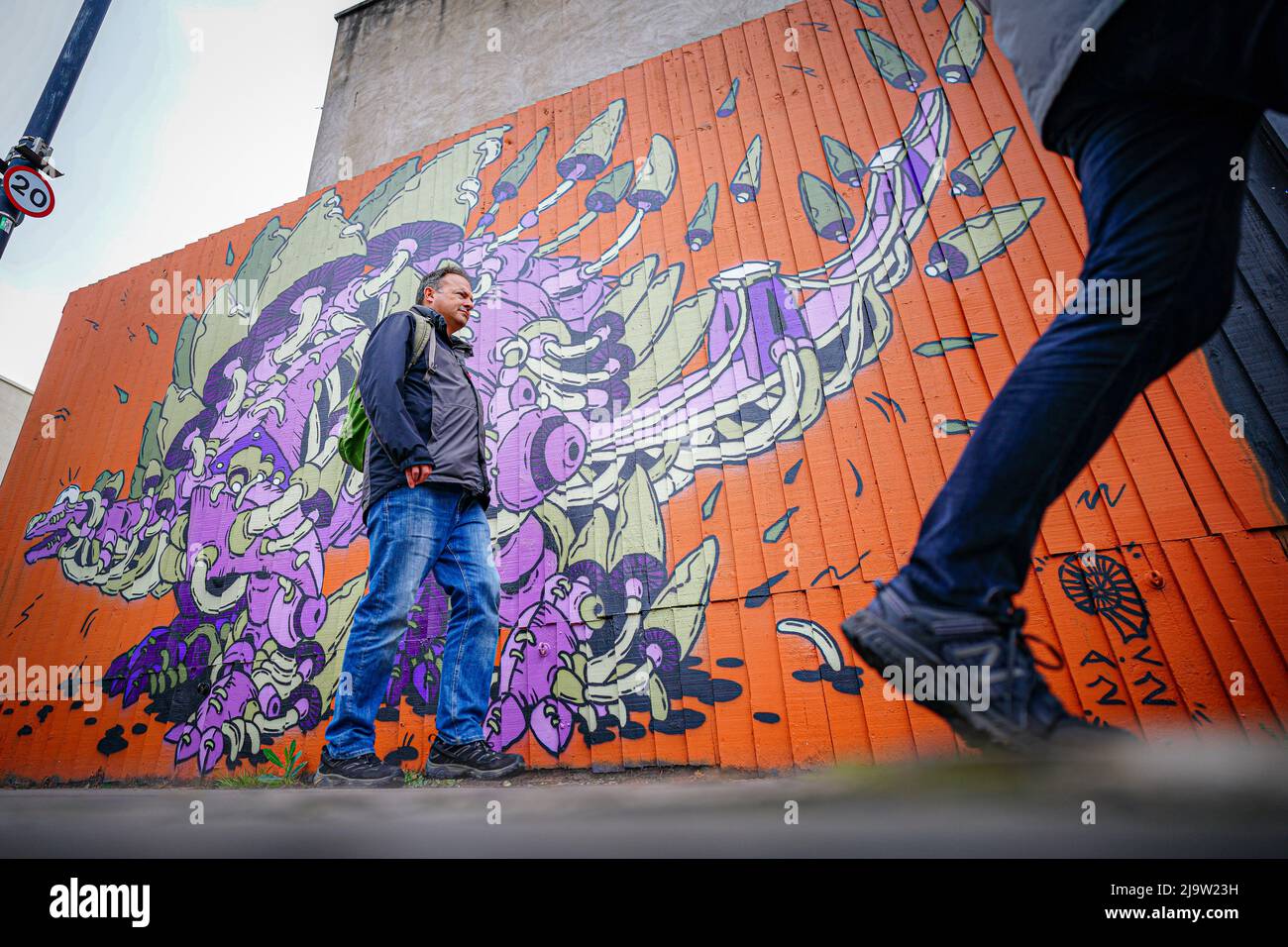 Les gens passent devant une œuvre d'art sur le thème des dinosaures à Bedminster, Bristol, dans le cadre du festival Upfest, le plus grand festival d'art de rue et de graffitis d'Europe. Date de la photo: Mercredi 25 mai 2022. Banque D'Images
