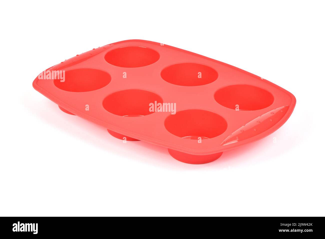 Forme en silicone rouge pour cuire des muffins et des cupcakes sur fond blanc. Vue latérale. Photo haute résolution. Profondeur de champ complète. Banque D'Images