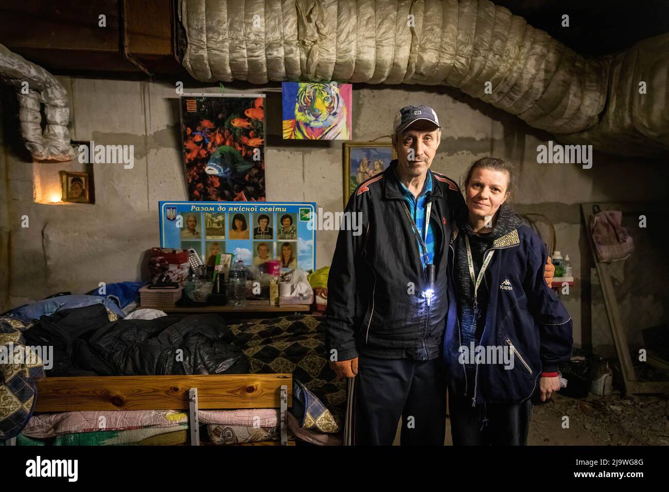 Sergei et sa femme Alina posent pour la photo comme ils vivent maintenant ensemble dans un bunker souterrain à Kharkiv. Une ancienne école est maintenant transformée en bunker, car elle accueille plus de 100 000 citoyens vivant dans le district de Saltivka à Kharkiv, qui ont été contraints d'adopter une nouvelle vie sous terre dans des bunkers sans électricité ni eau, dans le cadre de bombardements intensifs et constants de frappes aériennes russes. Banque D'Images