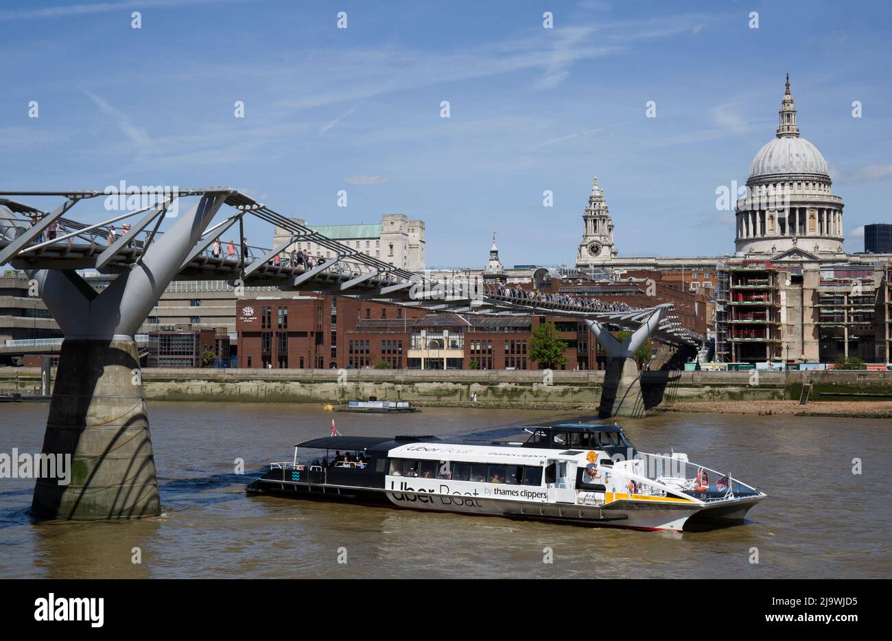 Un bateau touristique passe sous le pont du millénaire et le dôme de la cathédrale Saint-Paul de Londres Banque D'Images