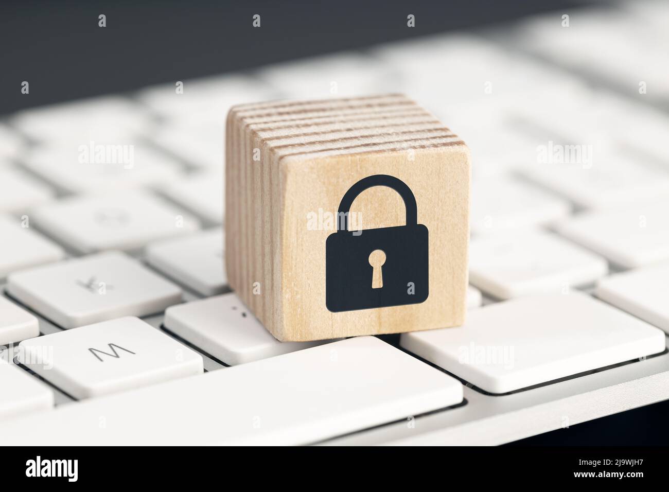 Concept de protection de la sécurité informatique. Protection contre les cyber-attaques. Icône de cadenas fermé sur le bloc en bois du clavier de l'ordinateur Banque D'Images