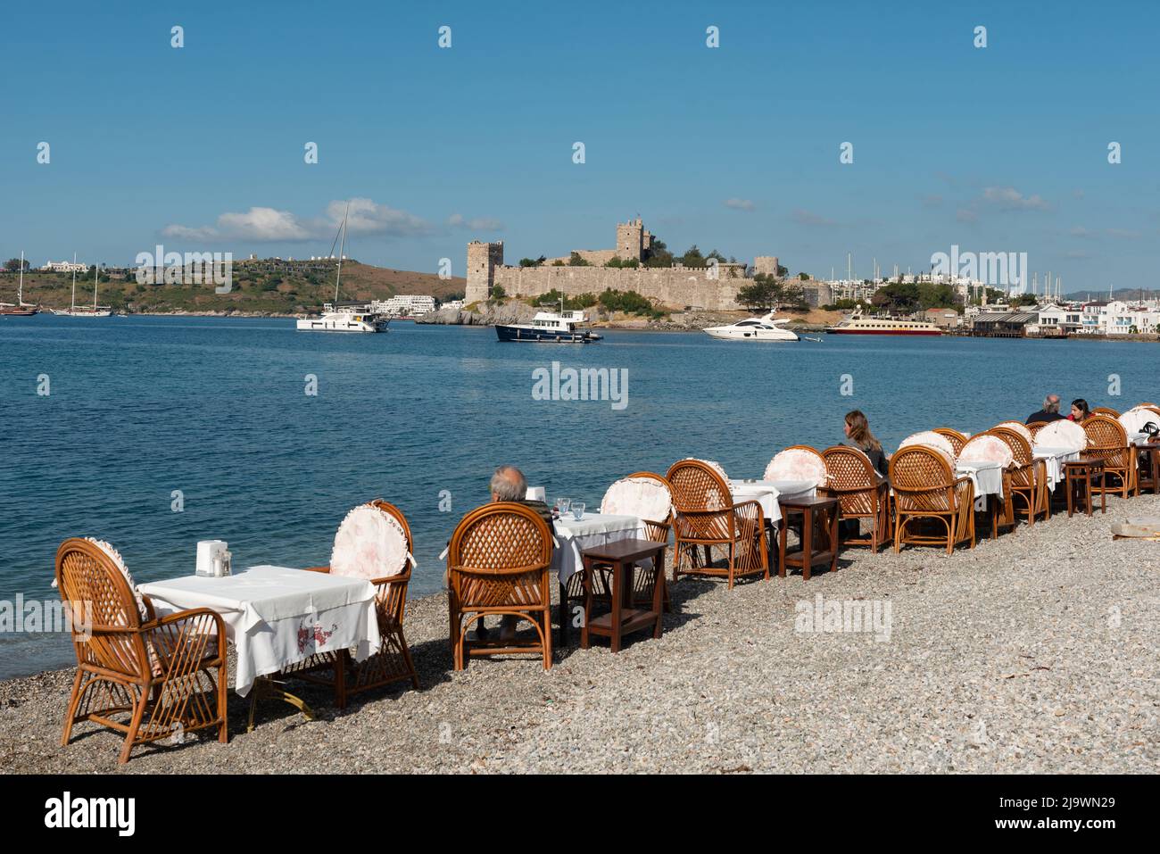 Bodrum, Turquie. 21st avril 2022. Tables de restaurant sur la plage dans le port de Bodrum avec le château de Bodrum en arrière-plan, la côte égéenne du sud-ouest de la Turquie. (Photo de John Wreford/SOPA Images/Sipa USA) crédit: SIPA USA/Alay Live News Banque D'Images