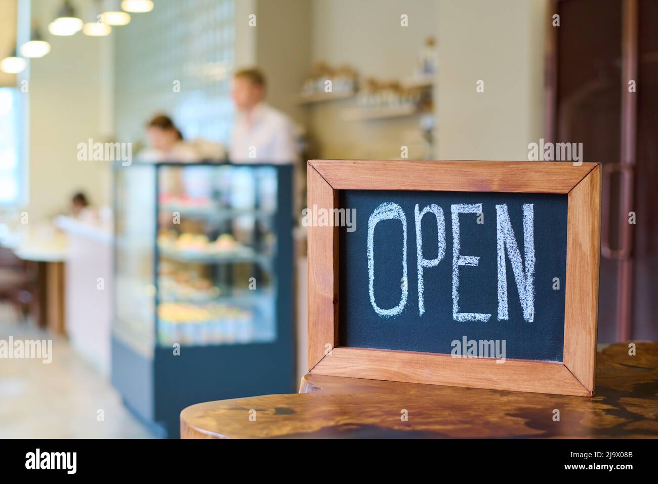 Gros plan de bois avec panneau ouvert écrit par craie sur la table dans le café-restaurant Banque D'Images Gros plan de bois avec panneau ouvert écrit par craie sur la table dans le café-restaurant Banque D'Images