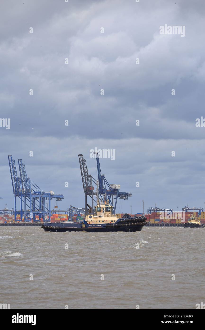 Remorqueur Svitzer Deben aidant un navire à conteneurs à quitter le port de Felixstowe. Banque D'Images