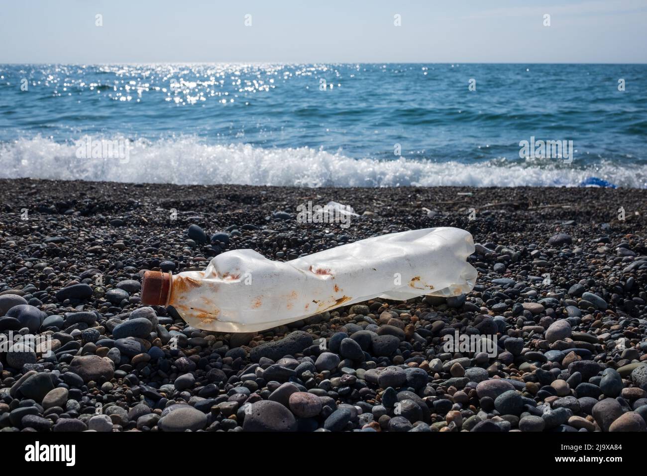 Vider la bouteille en plastique usagée sur le fond de la plage. Concept de pollution de l'environnement Banque D'Images