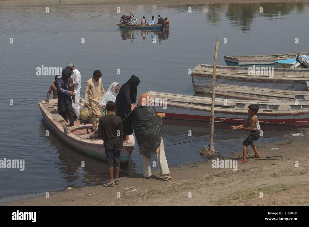 Les Pakistanais transportant leurs marchandises dans des bateaux pour traverser le fleuve Ravi alors qu'ils sont bloqués sur la route en raison de la fermeture des routes après l'application de l'article 144 en raison de mesures de sécurité pour la manifestation et la longue marche du PTI vers Islamabad depuis Lahore. Les autorités pakistanaises ont bloqué mercredi toutes les routes principales vers la capitale Islamabad, après qu'un ancien Premier ministre rebelle Imran Khan ait déclaré qu'il marrerait avec des manifestants dans le centre-ville pour un rassemblement qu'il espère faire tomber le gouvernement et forcer des élections anticipées. (Photo de Rana Sajid Hussain/Pacific Press) Banque D'Images