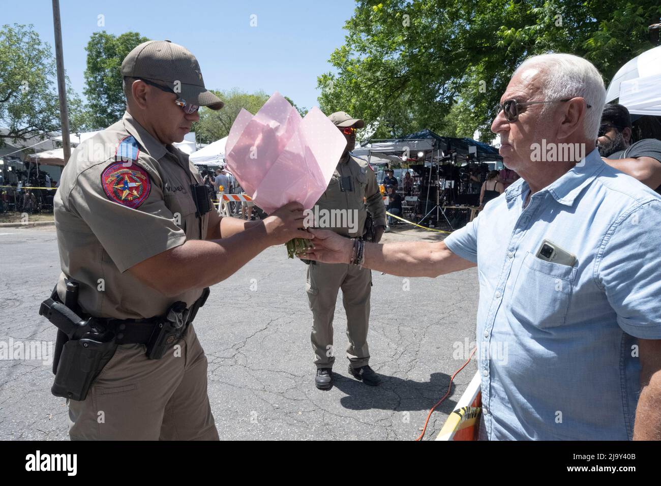 Uvalde, États-Unis. 25th mai 2022. Un officier de la sécurité publique du Texas recueille des fleurs des résidents d'Uvalde à l'extérieur de l'école élémentaire Robb dans le sud d'Uvalde où un homme seul a tué 19 écoliers et 2 enseignants le 24 mai 2022 crédit: Bob Daemmrich/Alay Live News Banque D'Images