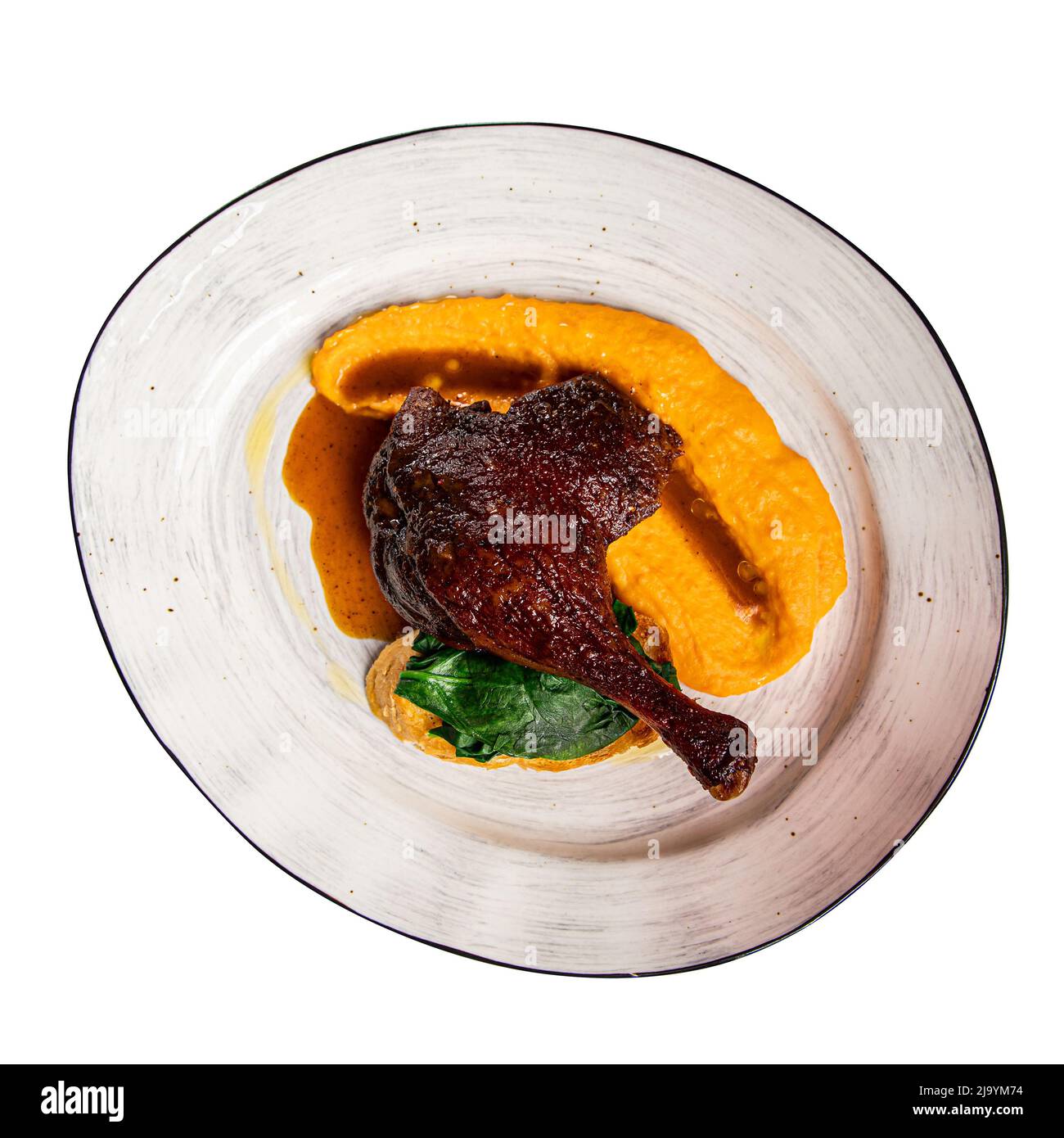 Assiette isolée de cuisse de canard confit avec purée Banque D'Images