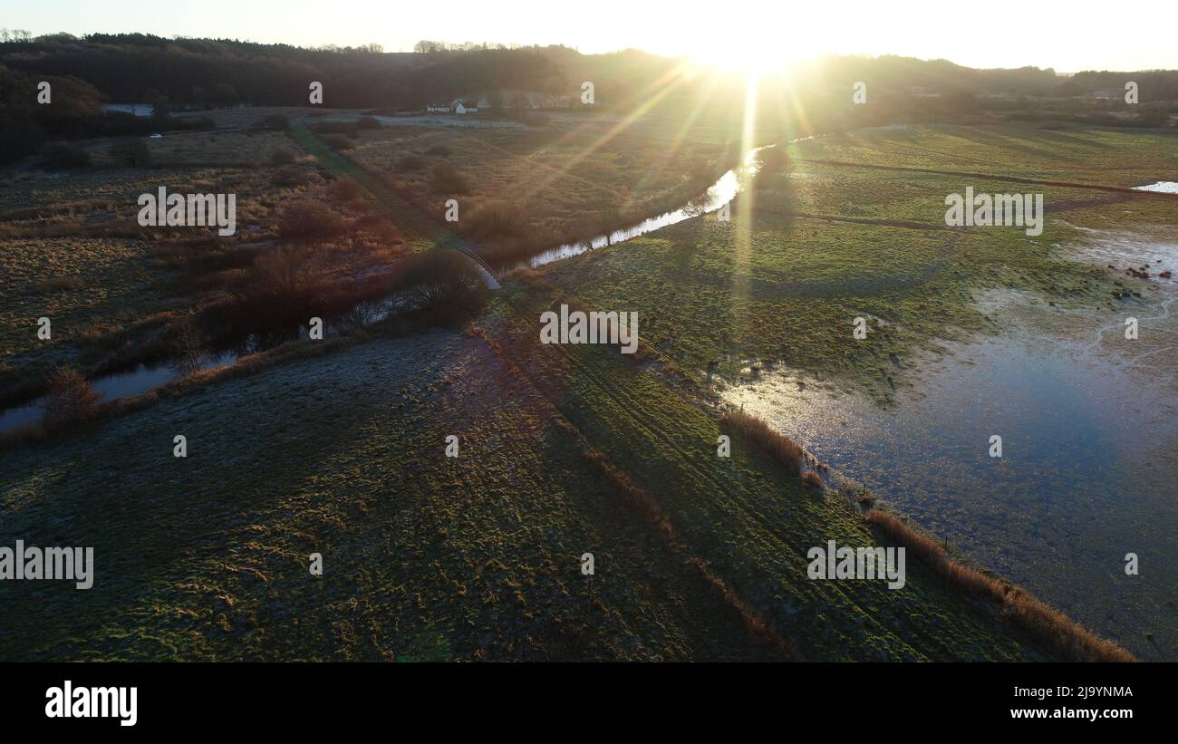 Prés humides de Ravening dans le sud du Jutland, Danemark où un long pont en chêne traverse la rivière Vejle et de basses prairies pendant l'âge des Vikings (980 après J.-C.) Banque D'Images