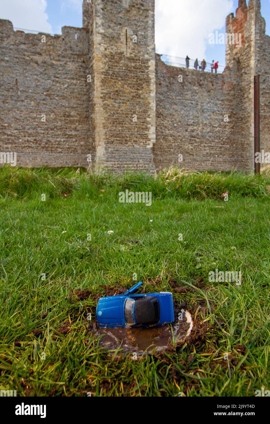 Une voiture bleue en avant-plan, derrière le château de Framingham datant du 13th siècle, Suffolk Banque D'Images