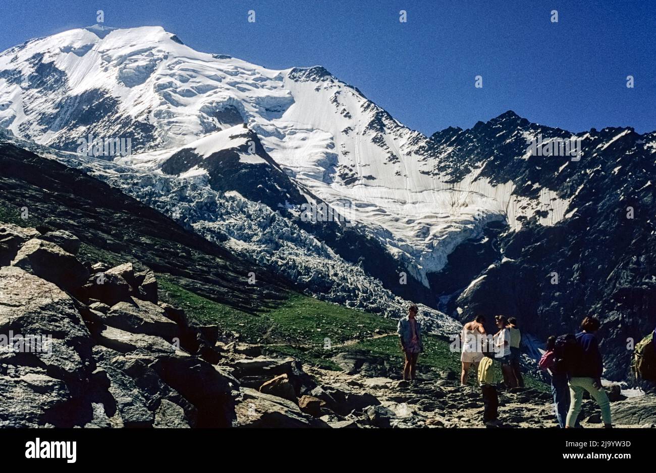 Aiguille de Bionnassay avec champs de firn, Glacier de Bionnassay du Nid d'Aigle. Touristes en premier plan. Saint-Gervais-les-bains, France, 1990 Banque D'Images