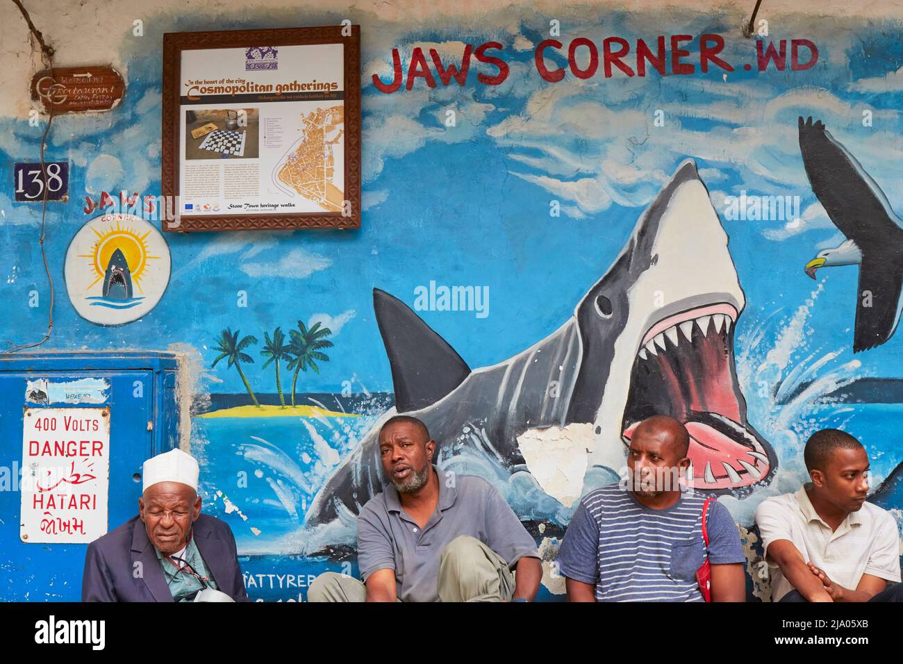 Les gens assis dans le coin des mâchoires de Stone Town, Zanzibar, Tanzanie, Afrique. Banque D'Images