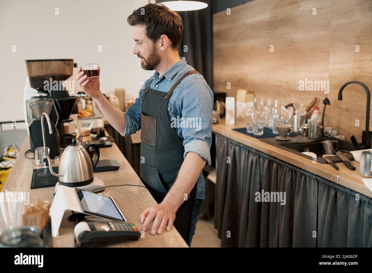 le barista évalue un verre de café filtre Banque D'Images