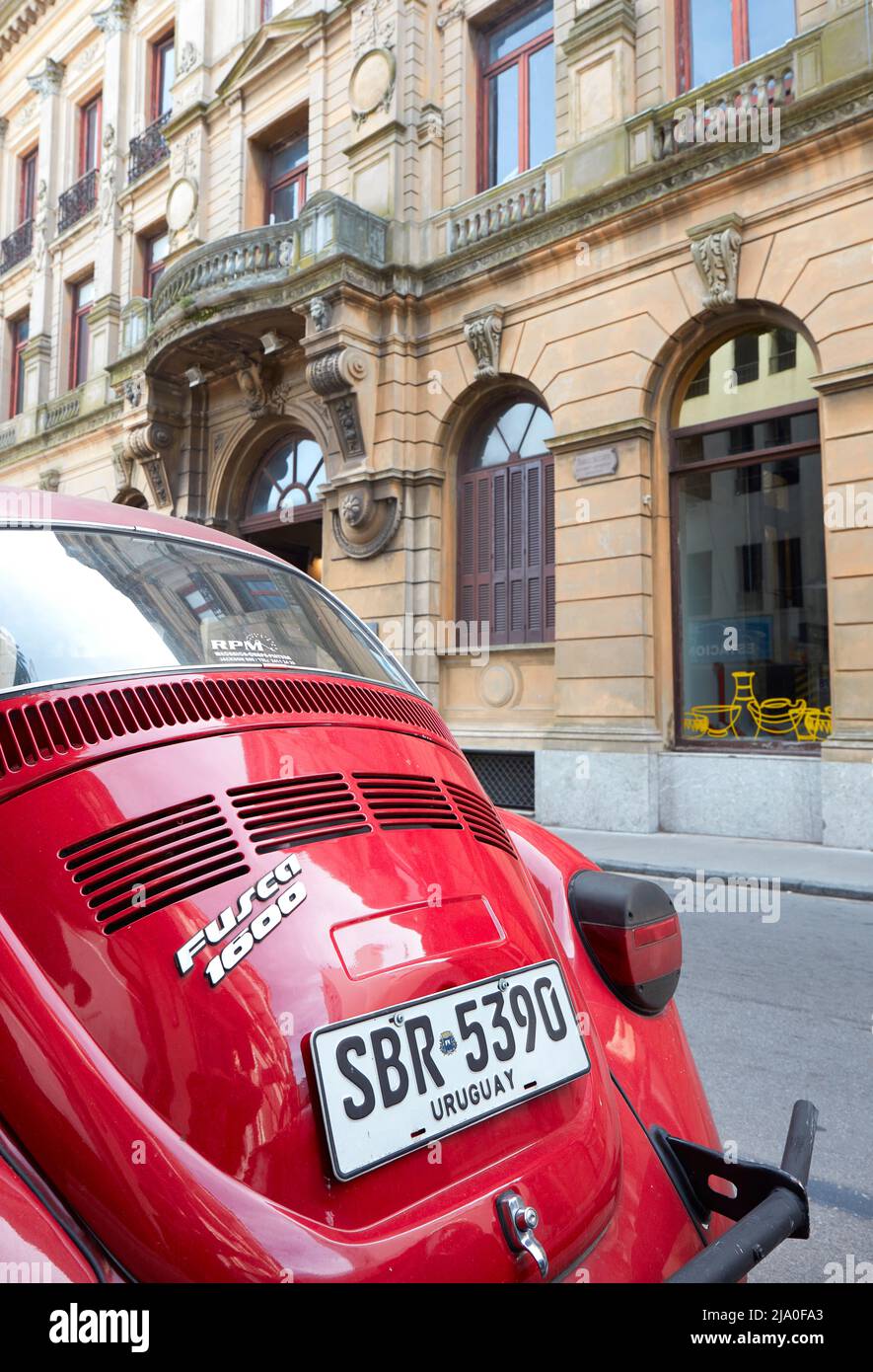 Voiture Volkswagen Bettle Fusca d'époque rouge dans une rue de Montevideo avec un bâtiment d'architecture de style colonial en arrière-plan, Uruguay. Banque D'Images