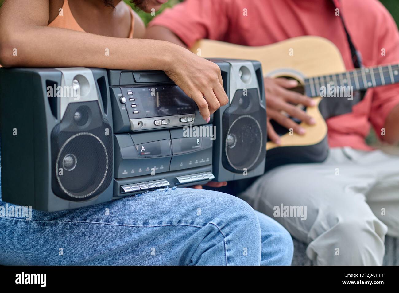 Main femelle touchant un joueur de disque, homme à guitare Banque D'Images