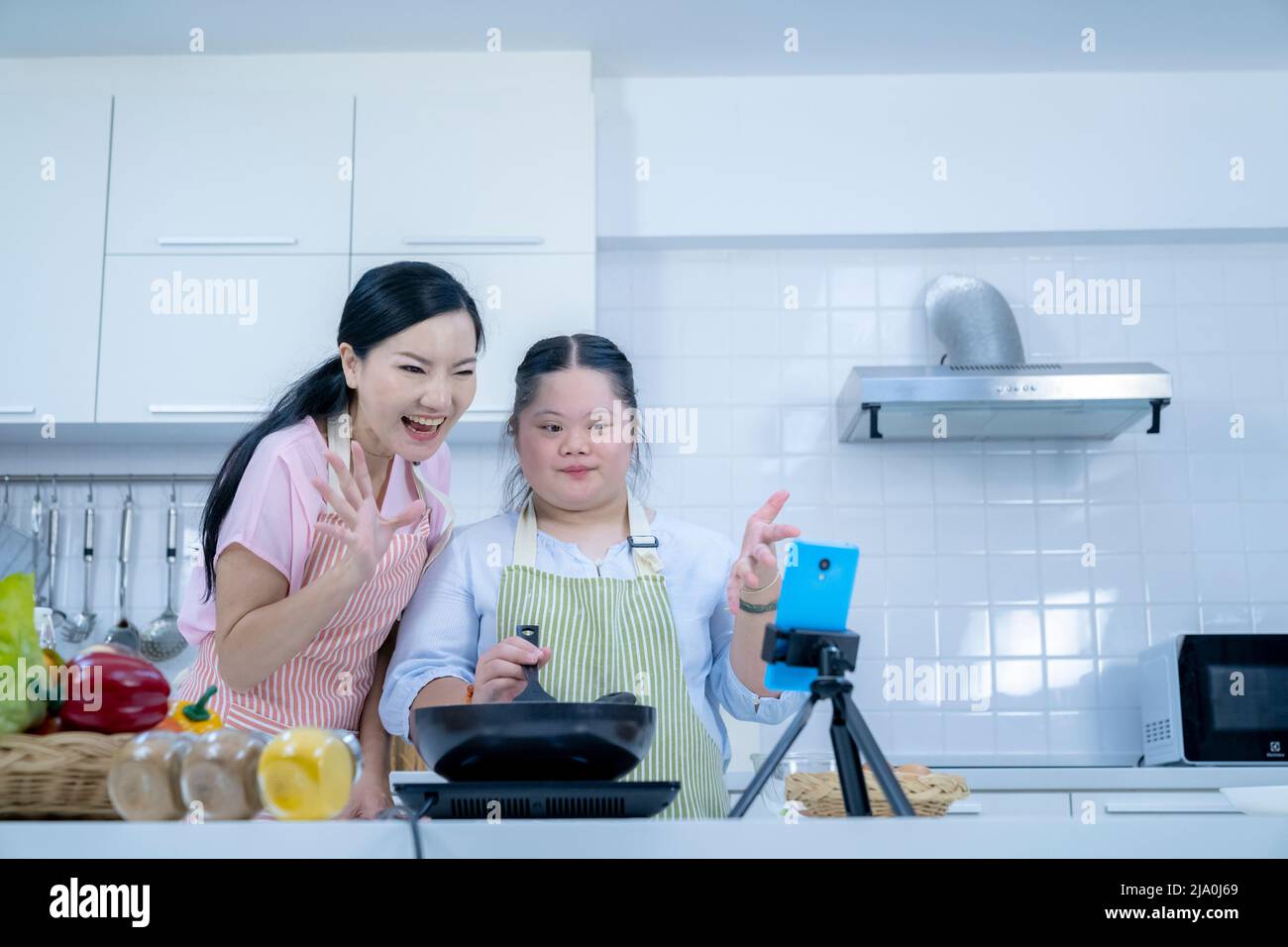 Asiatique personne avec le syndrome de Down cuisiner avec maman. Croissance du cerveau apprentissage famille amour intelligence cuisine Banque D'Images