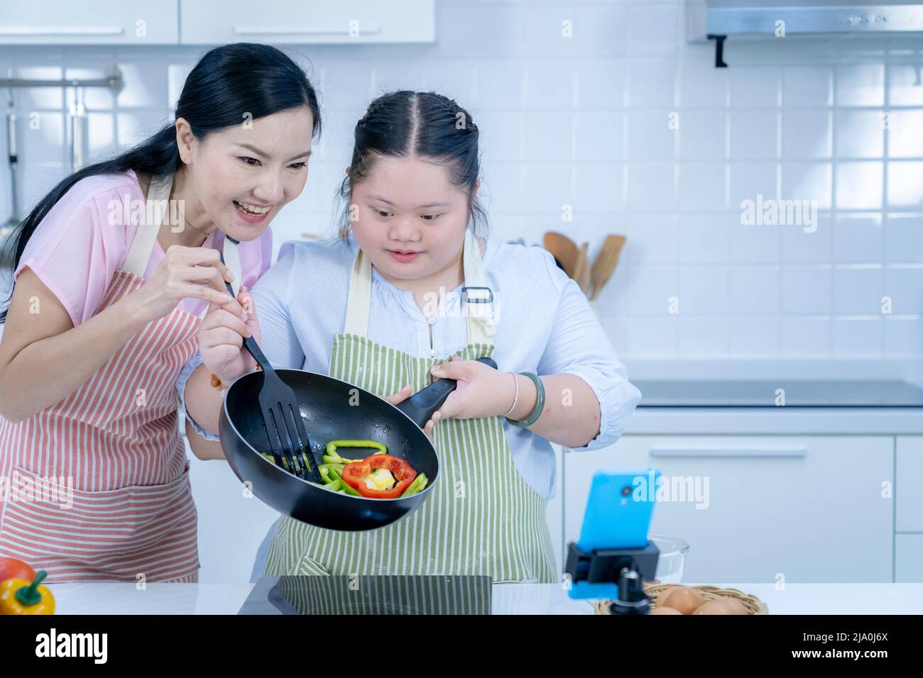 Asiatique personne avec le syndrome de Down cuisiner avec maman. Croissance du cerveau apprentissage famille amour intelligence cuisine Banque D'Images