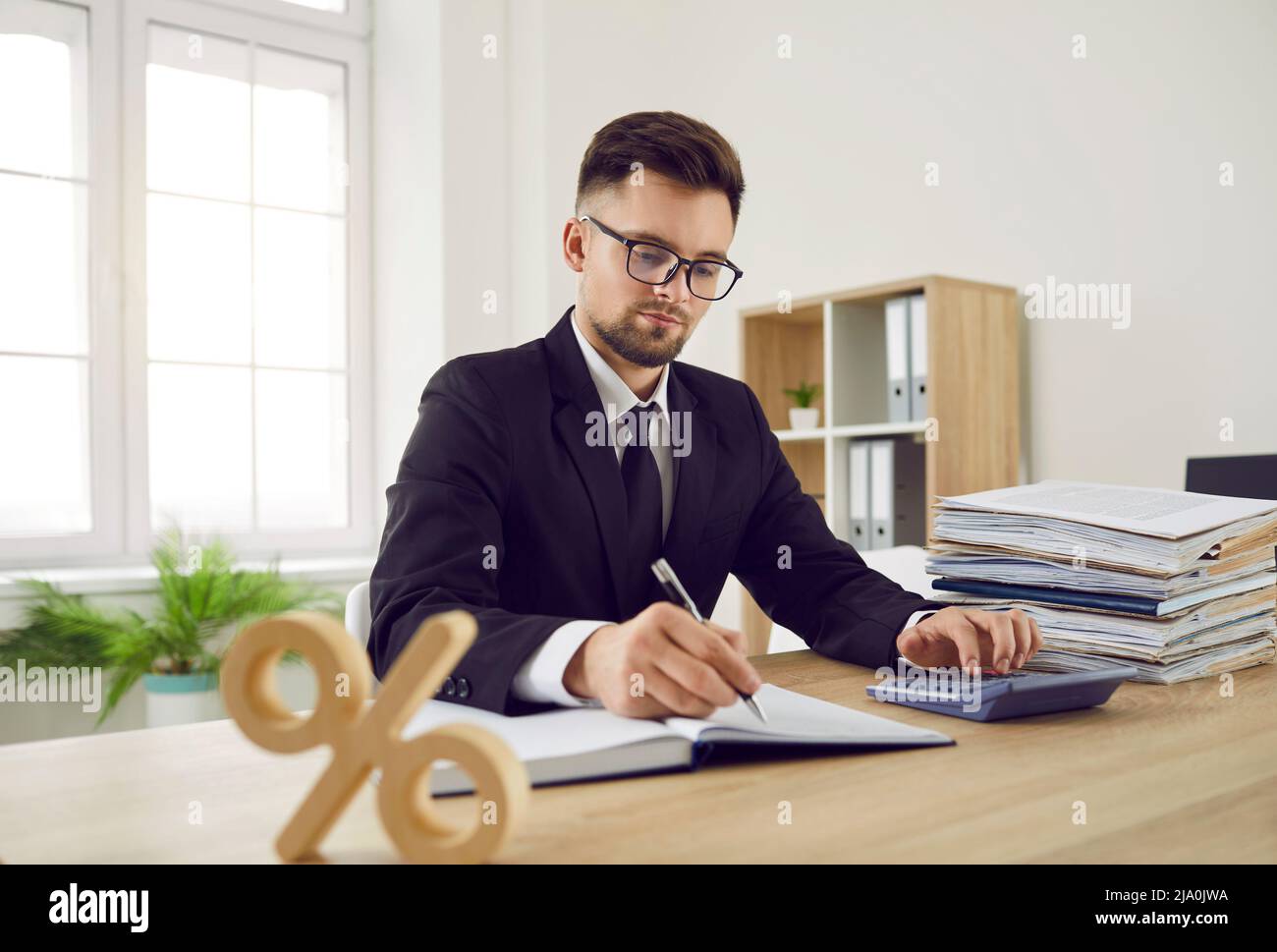 Comptable d'affaires au bureau de travail, qui calcule l'impôt des sociétés et le taux d'intérêt en pourcentage Banque D'Images