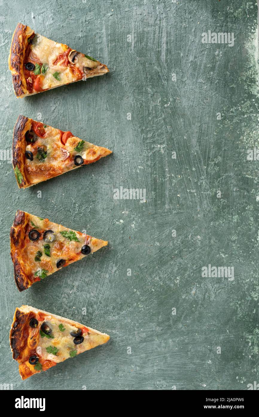 Plusieurs tranches de pizza sur fond vert avec espace de copie Banque D'Images