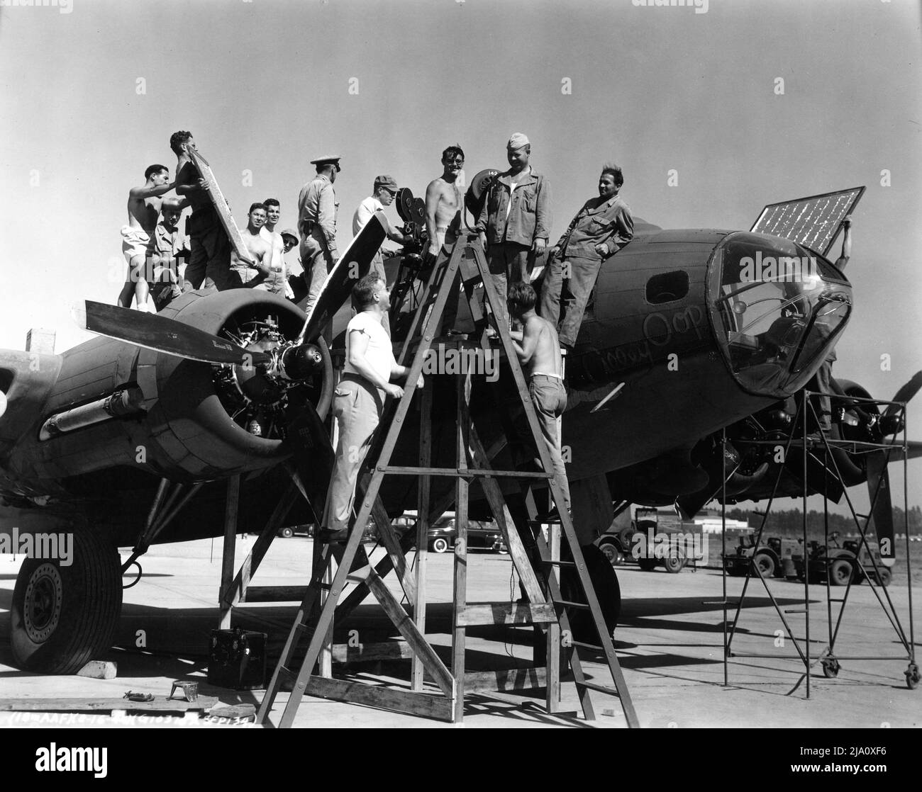 L'équipage de caméra et l'équipage de l'air font du film de propagande de l'Armée de l'Air US 18th sur place, candid sur un terrain d'aviation filmant autour d'un avion militaire le 16th août 1944 Banque D'Images