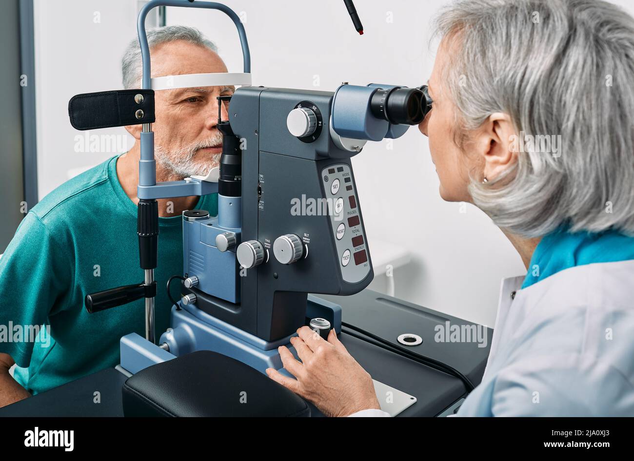 Optométriste expérimenté effectuant un test visuel pour un homme âgé à la clinique moderne d'ophtalmologie. Examen oculaire et diagnostic de la vision Banque D'Images