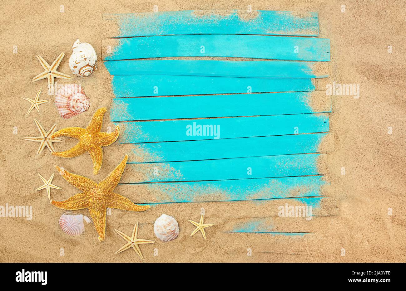 Planches en bois bleu avec étoiles de mer, coquillages dans le sable. Cadre d'été. Concept de vacances, mer, voyage. Copier l'espace Banque D'Images