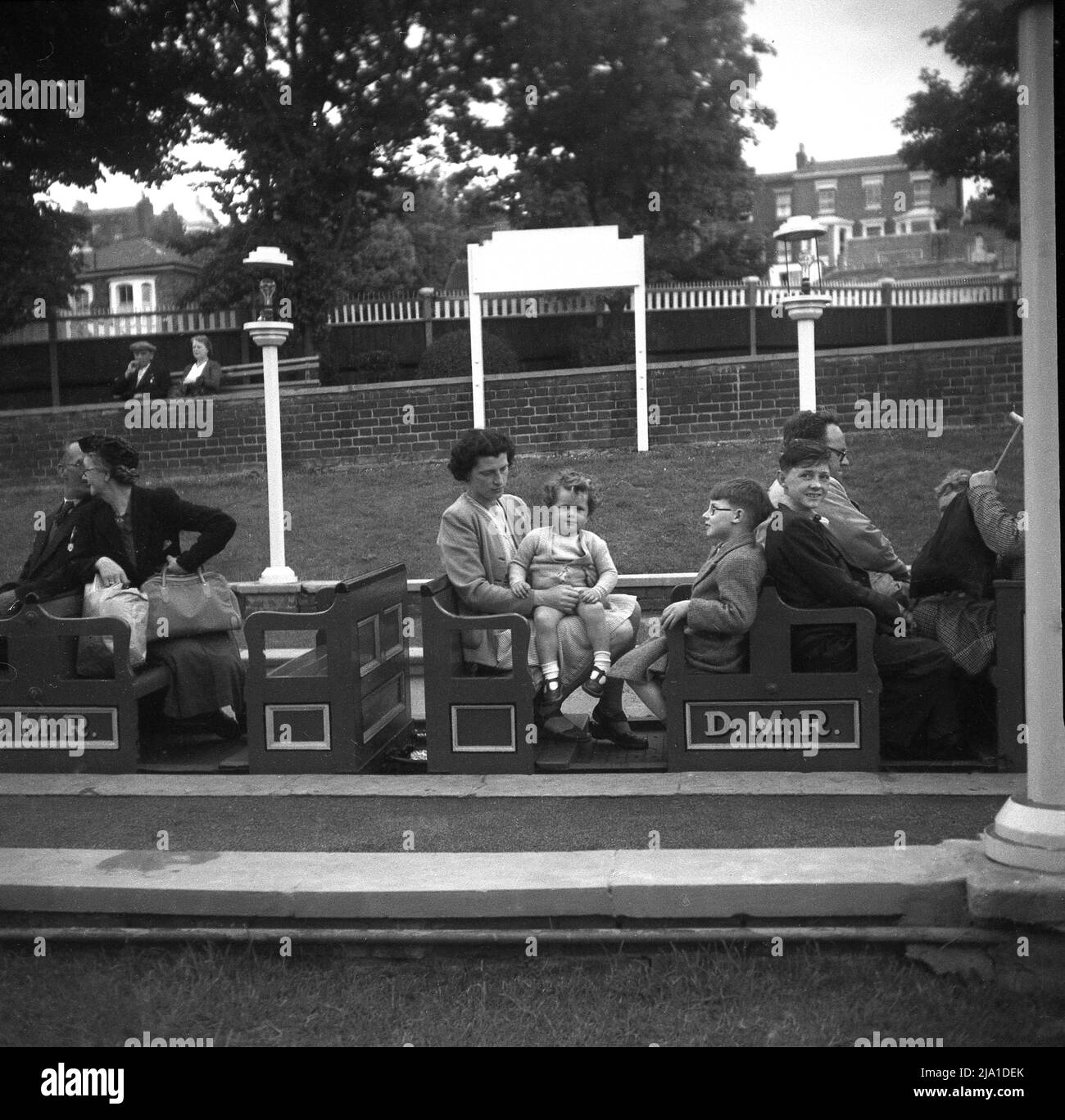 1950s, historique, familles assises dans les petites voitures de train à ciel ouvert au Dreamland miniature Railway (DMR), Margate, Kent, Angleterre, Royaume-Uni. Conçu par le mécanicien de chemin de fer miniature Henry Greenly et ouvert en 1920, le train à vapeur miniature de 15' de jauge a traversé le parc d'attractions du célèbre site Margate Dreamland. Le chemin de fer a fermé en 1979. Banque D'Images