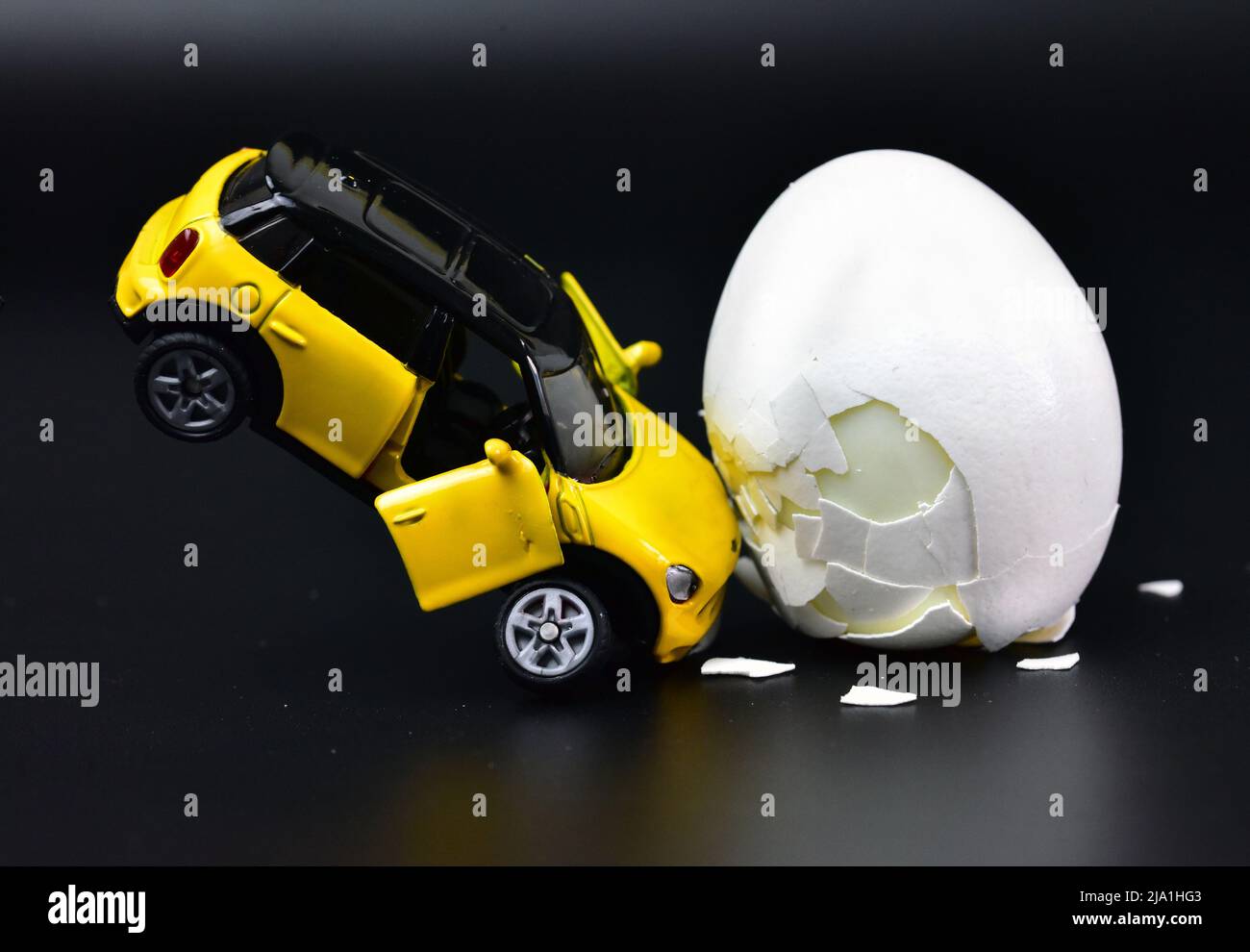accident de voiture jouet drôle avec un oeuf de poulet Banque D'Images