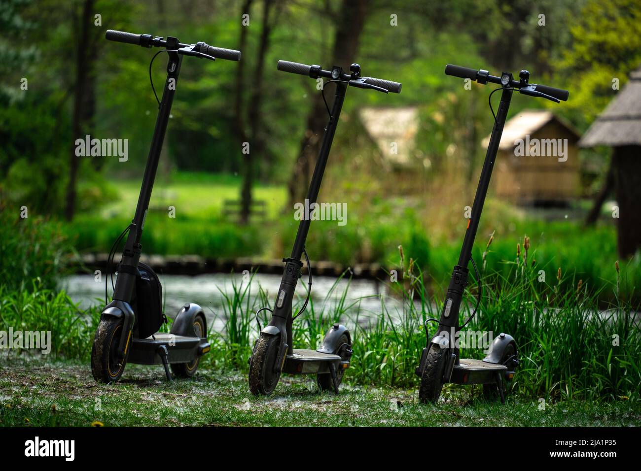 Sződliget, Hongrie - Apr 30 2022: Mobilité durable - avenir du transport: Trois scooters électriques debout dans un parc vert en ligne Banque D'Images