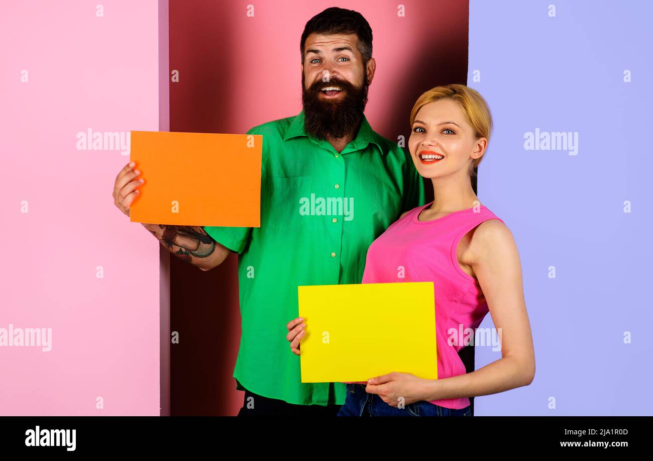 Couple souriant présentant un tableau publicitaire. Bannières vides avec espace de copie pour le texte. Shopping. Vente. Banque D'Images