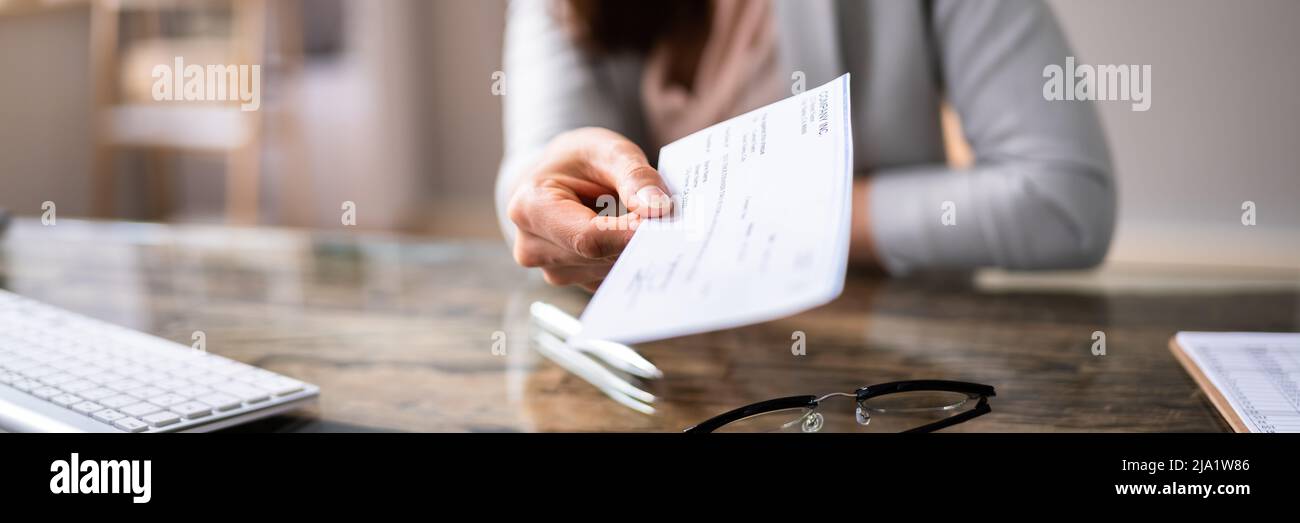 Close-up de l'homme d'affaires's Hand Holding Check In Office Banque D'Images