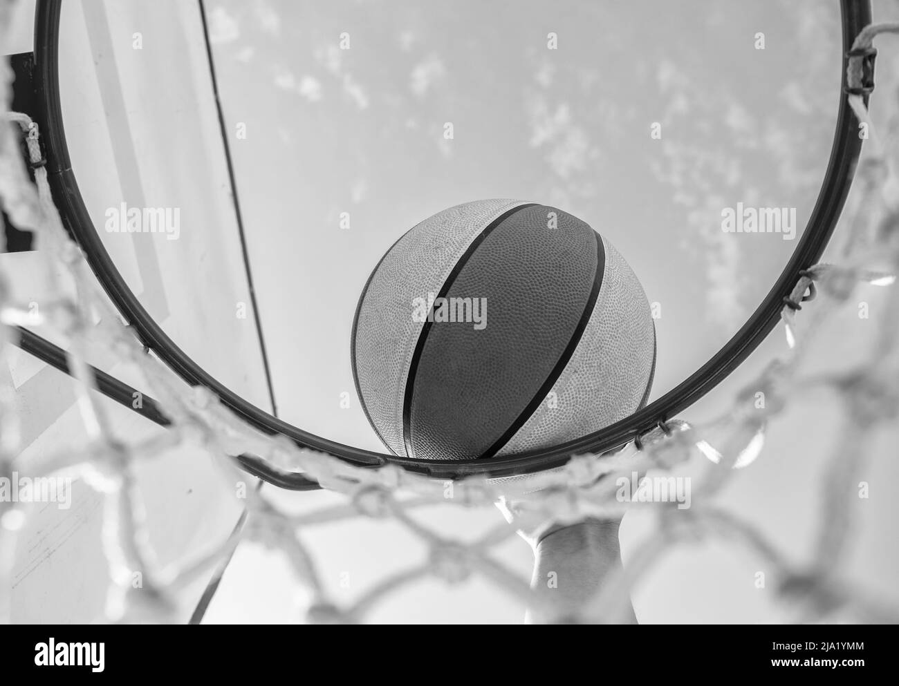 le ballon de basket-ball est à l'intérieur d'une bague en filet avec la main, basket-ball Banque D'Images