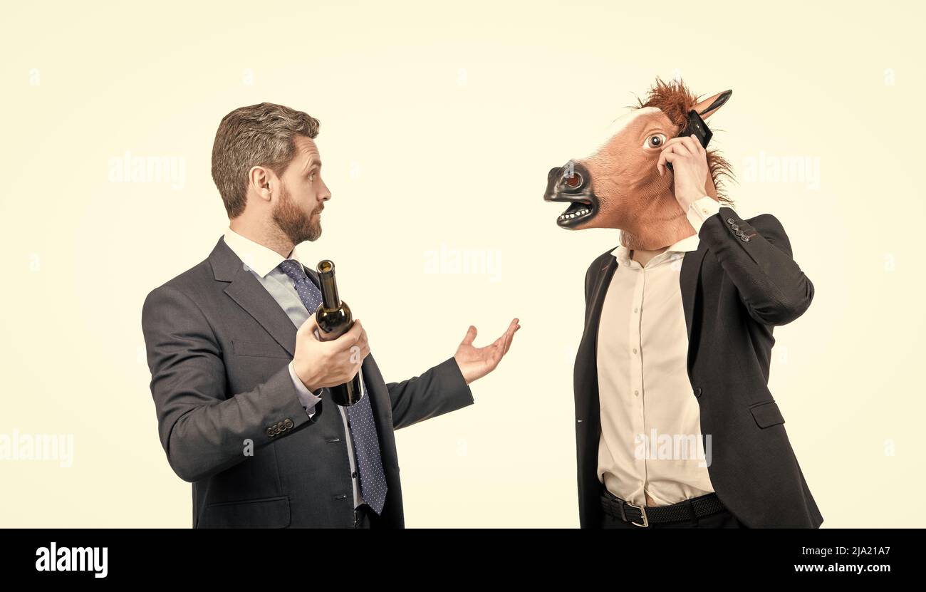 Communication d'entreprise. Homme portant une tête de cheval parler sur un téléphone portable. Communication d'entreprise Banque D'Images