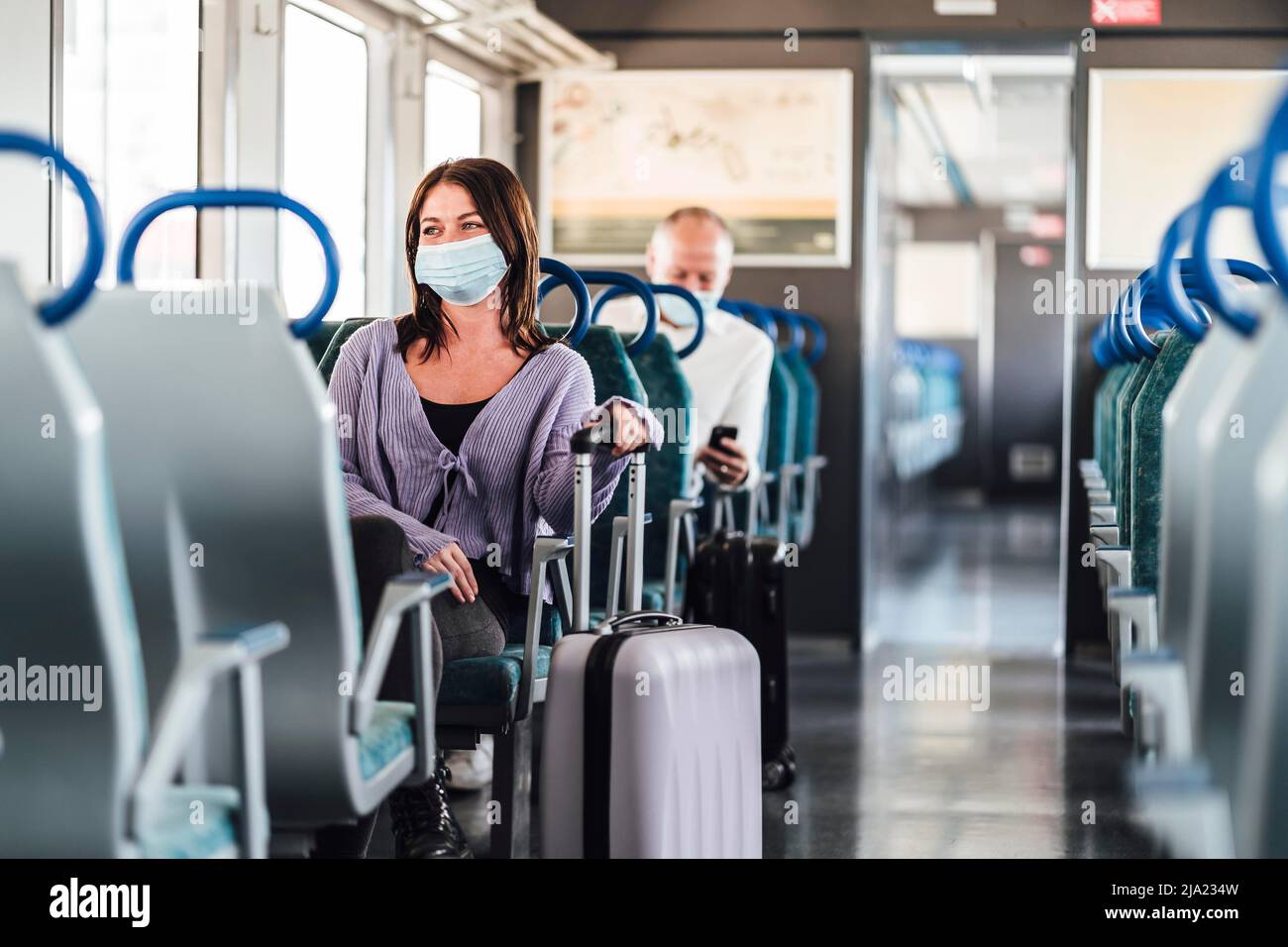 Passagers sérieux dans des masques de protection lors de leur excursion d'une journée en train Banque D'Images