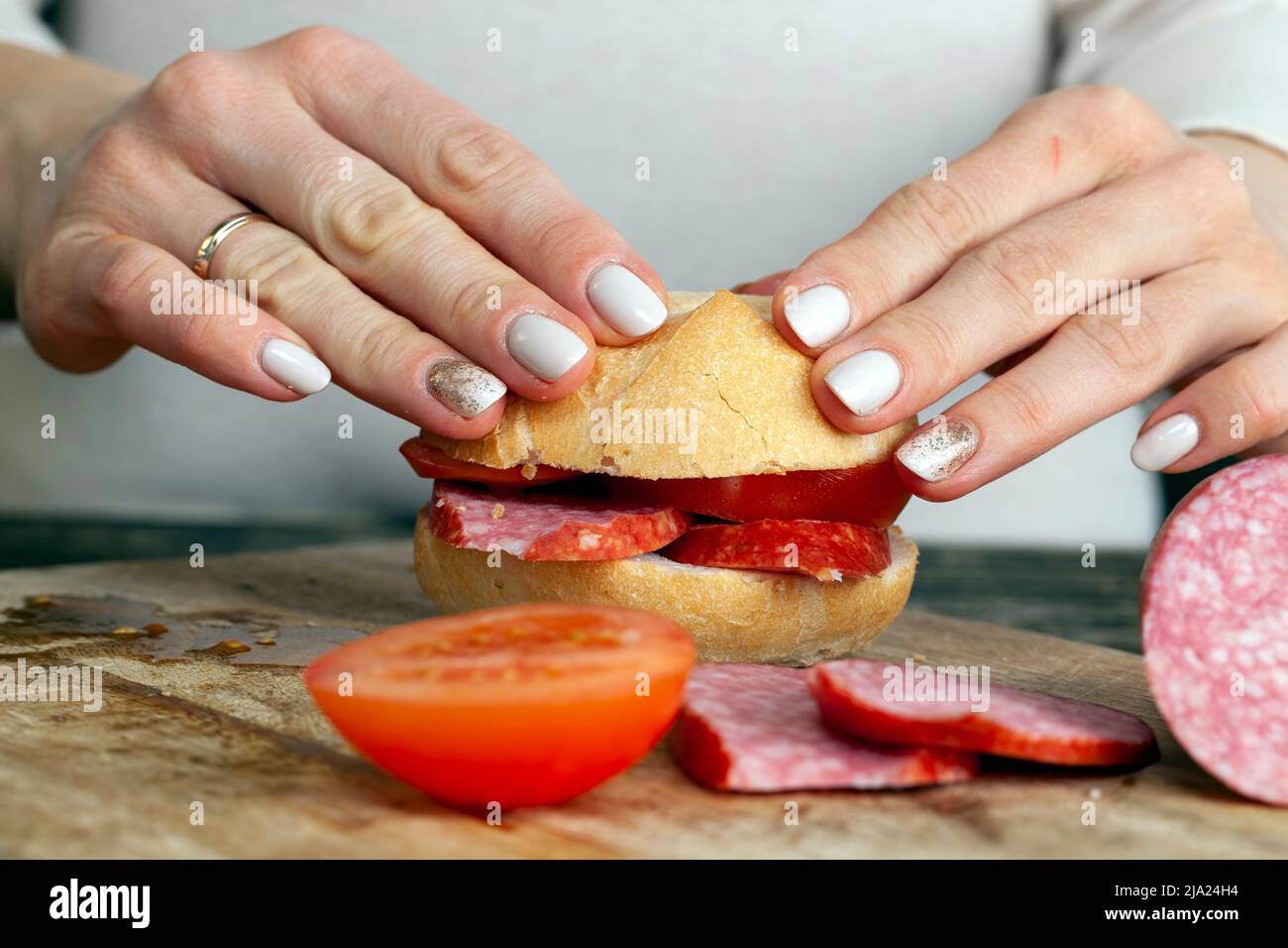 tranches de saucisse avec de la viande et du bacon et autres produits alimentaires pendant la préparation des sandwichs, faisant des sandwichs à la maison Banque D'Images