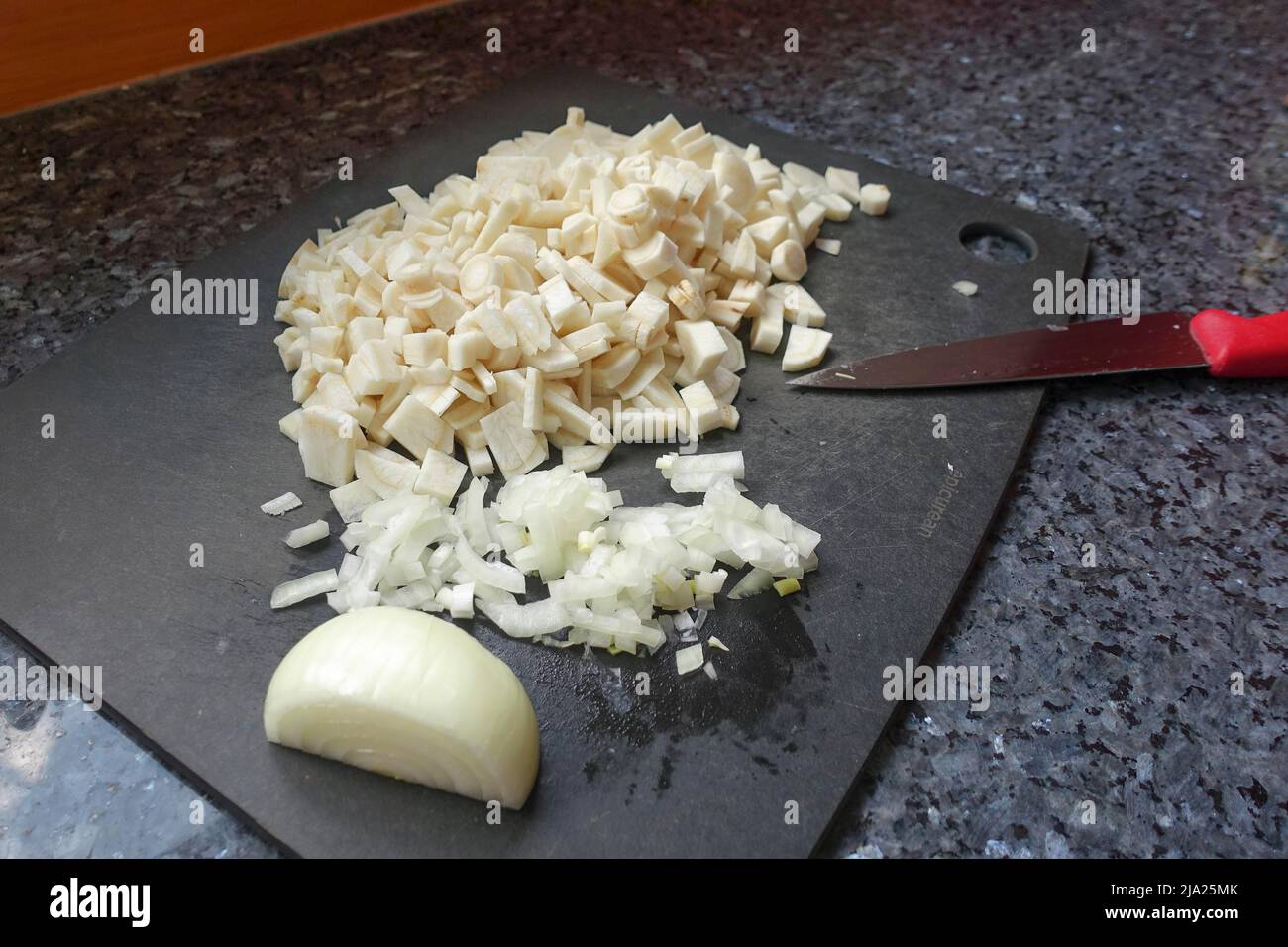 Cuisine souabe, préparation racine de persil (Petroselinum crispum subsp. Tuberosum) sur plan de cuisine, oignon, couteau, légumes d'hiver, traditionnel Banque D'Images