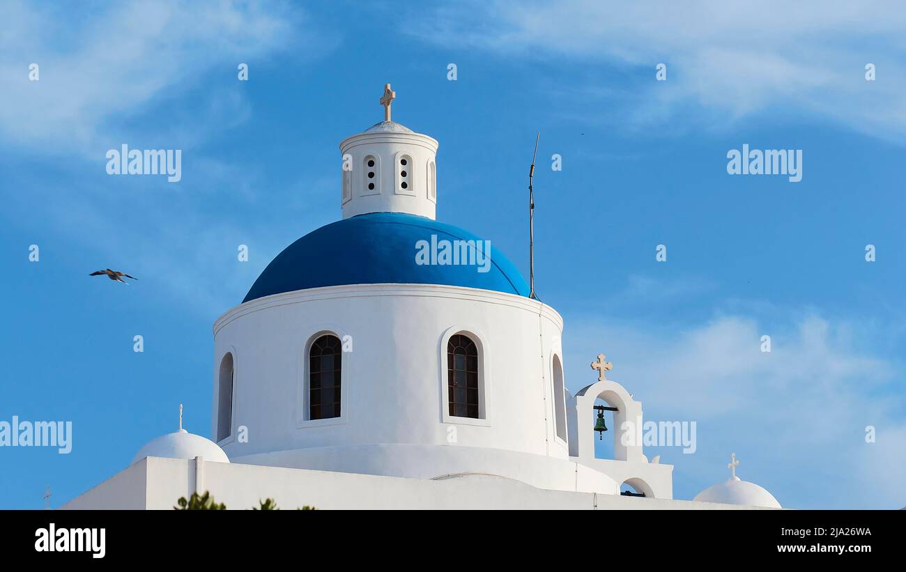 Dôme d'église rond bleu et blanc, ciel bleu avec des nuages blancs, OiaIsland Santorini, Cyclades, Grèce Banque D'Images