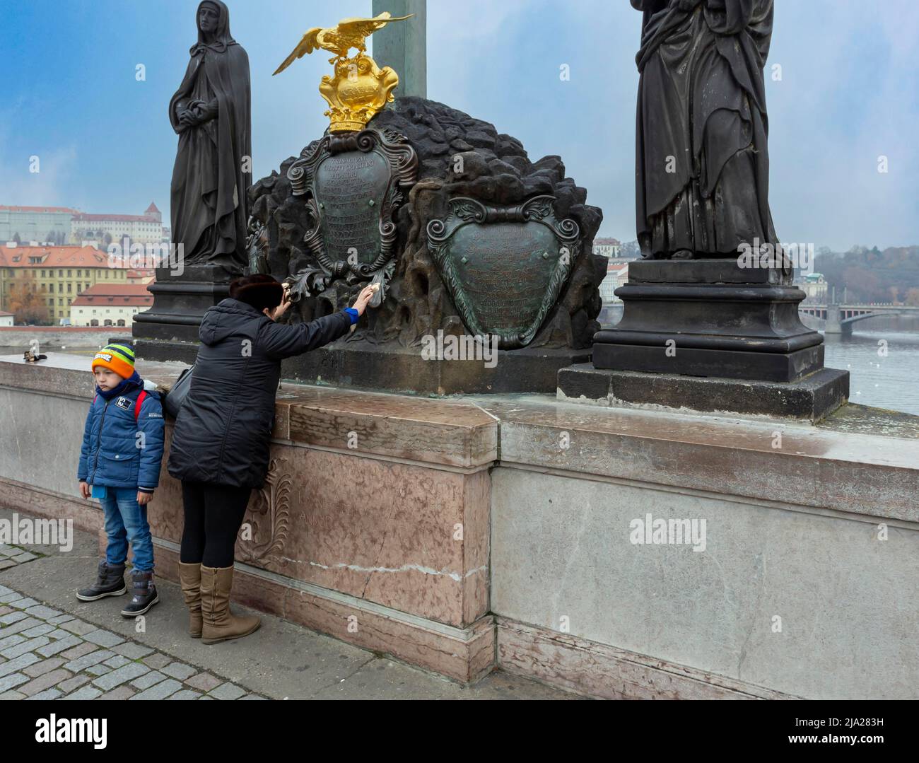 Priant une femme avec son enfant sur le pont Charles, Prague, République tchèque Banque D'Images