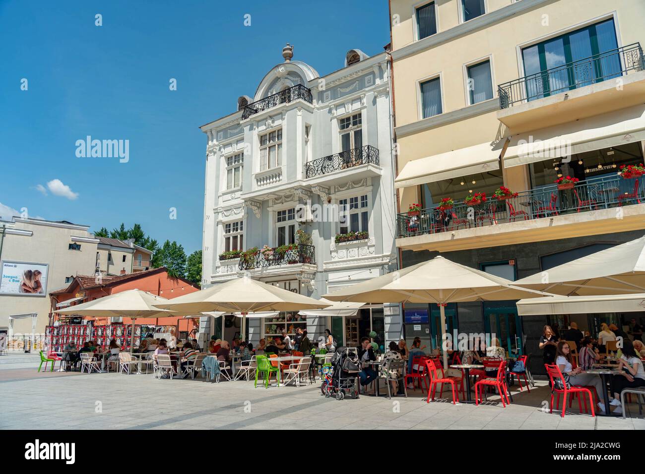 Plovdiv, Bulgarie - 23.05.2022: Les gens sont assis dans le Street Cafe à la journée en face des bâtiments historiques Banque D'Images