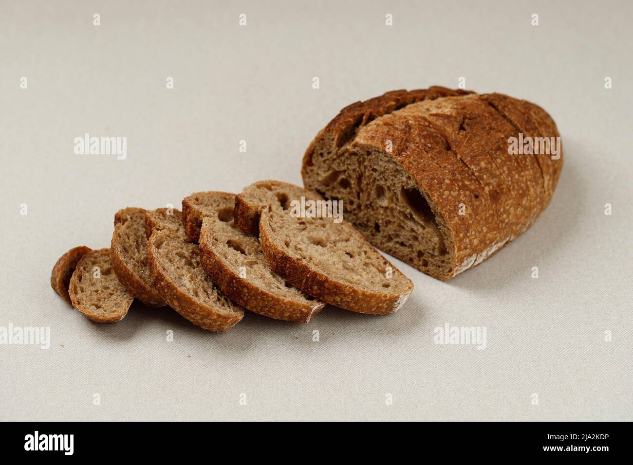 Coupez le pain Sourdough sur une table crème unie, espace de copie pour le texte Banque D'Images