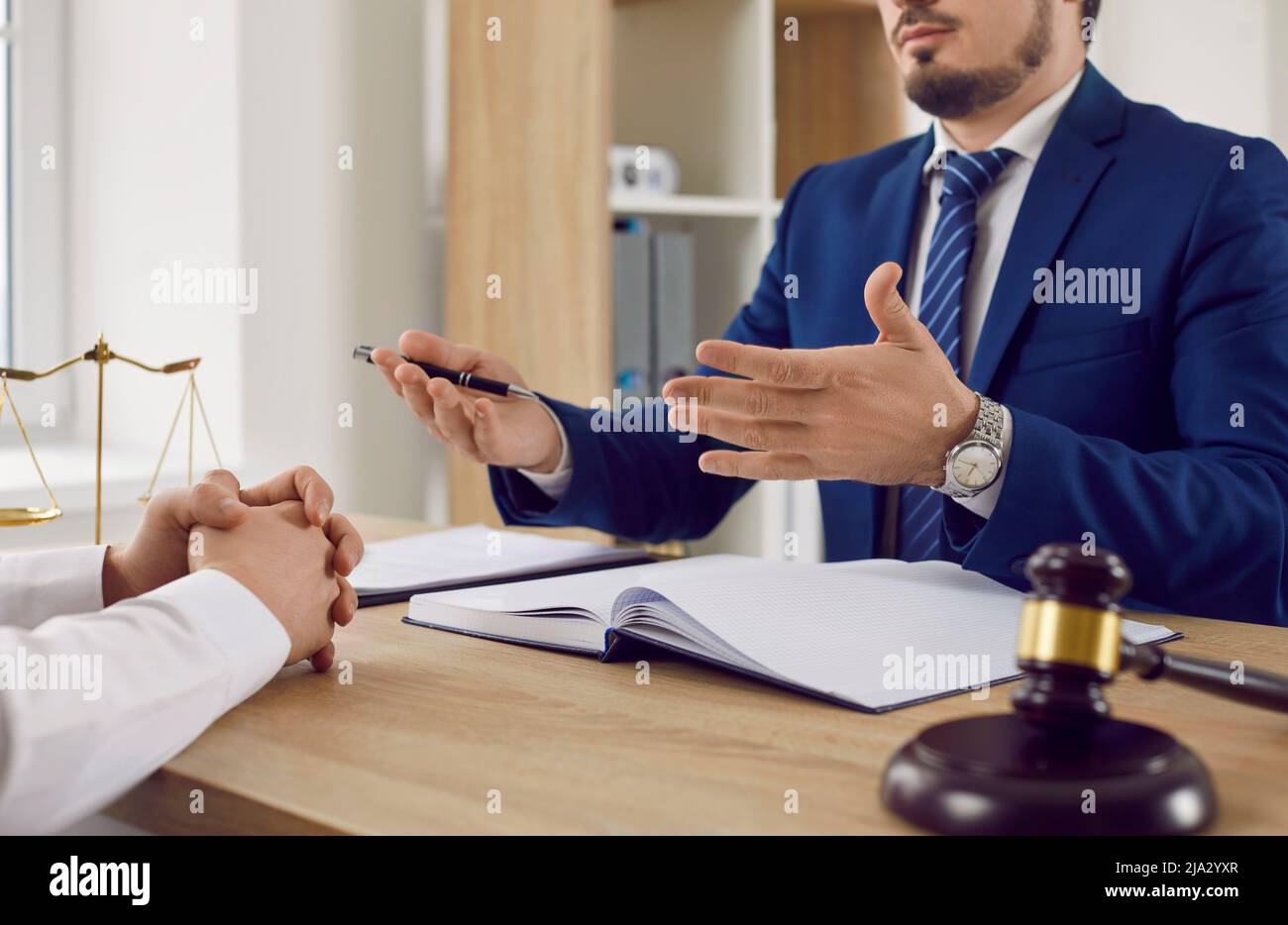 Un avocat masculin sérieux explique la situation juridique et discute de documents contractuels avec un client masculin. Banque D'Images