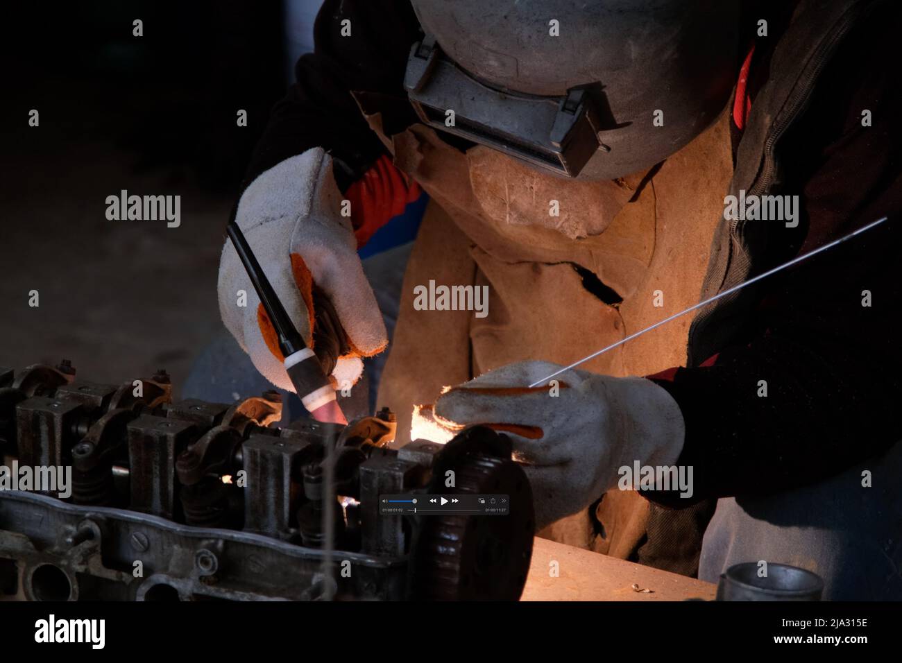Les hommes professionnels portant un masque de soudage et des gants travaillent dans un atelier à domicile avec du soudage à l'arc et de l'argon. Banque D'Images