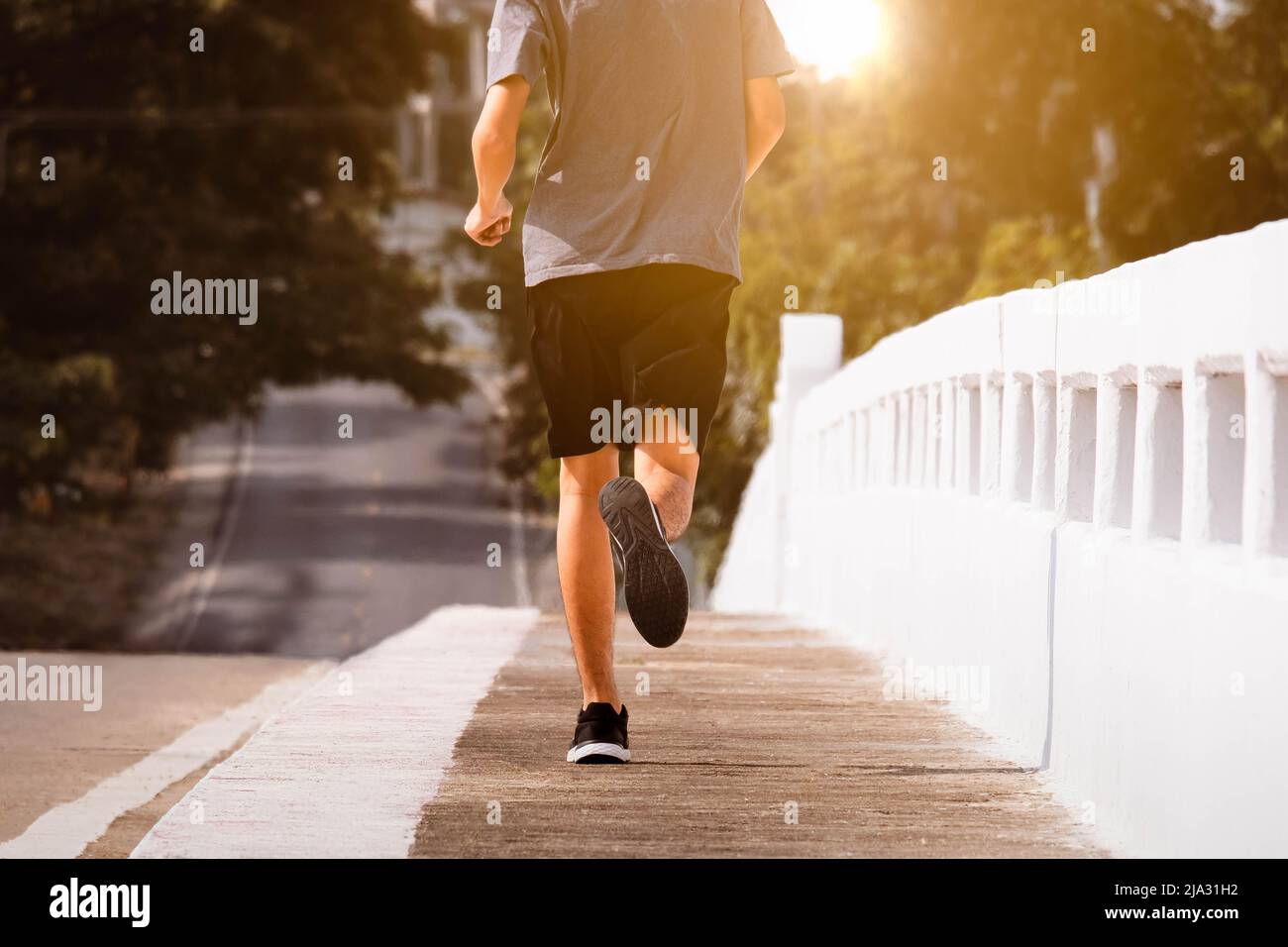 Jeunes hommes coureur pieds courir sur la route de pont de ville courir pour l'exercice. Concept d'exercice sain. Banque D'Images